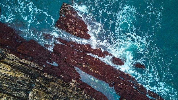 Tide pools off Maine coast from above with waves and rocks