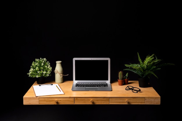 Foto scrivania in legno ordinata con laptop grigio