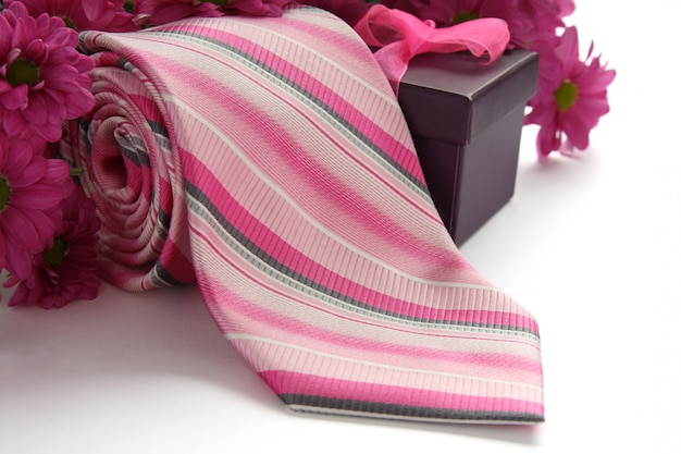 Tie and gift box with flowers over white