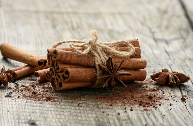 Tied bunch of brown cinnamon sticks on a gray wooden background, close up