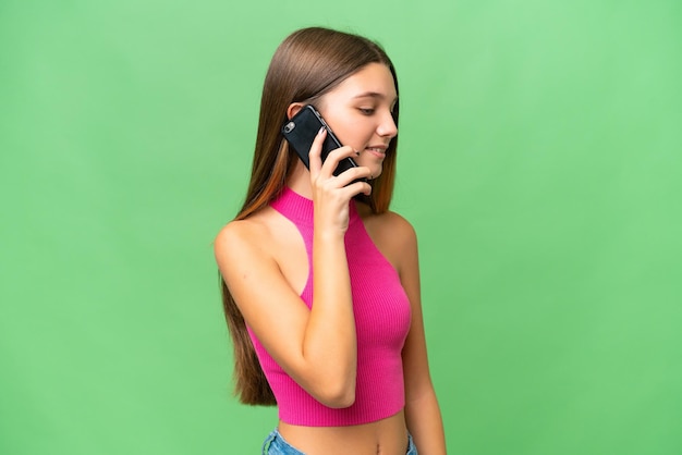 Tiener blank meisje over geïsoleerde achtergrond een gesprek voeren met de mobiele telefoon met iemand