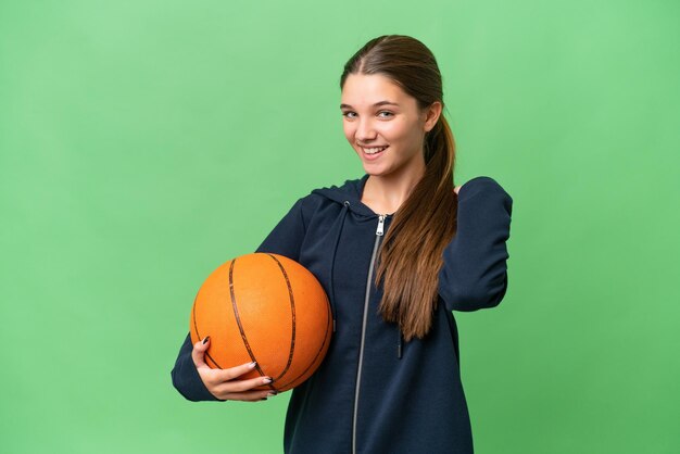 Tiener blank meisje speelt basketbal over geïsoleerde achtergrond lachen