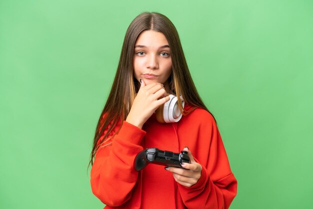 Tiener blank meisje speelt met een videogamecontroller over geïsoleerde achtergrond denken