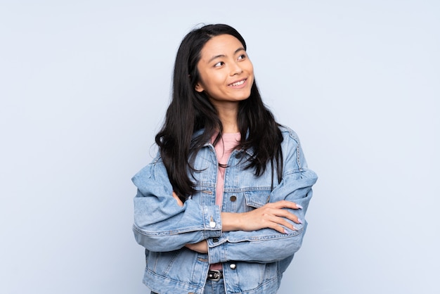 Tiener Chinese vrouw die op blauw wordt geïsoleerd