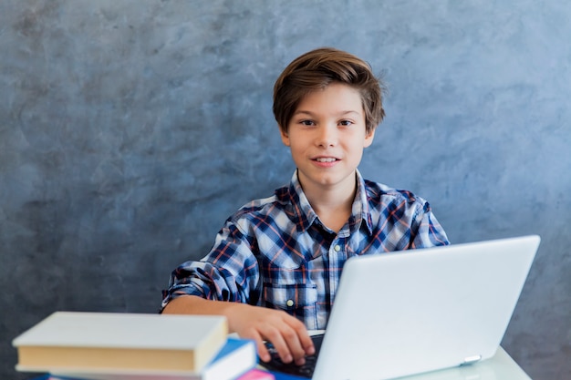 Tiener die aan laptop thuis werkt