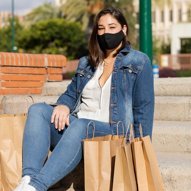 Foto tiener die een gezichtsmasker buitenshuis draagt