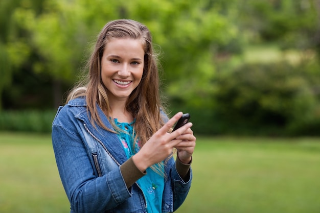 Tiener die een tekst met haar mobiele telefoon verzendt