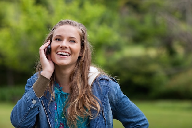 Tiener die haar mobiele telefoon met behulp van terwijl het tonen van een grote glimlach