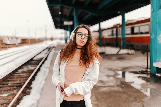 Tiener die op trein wacht te komen.