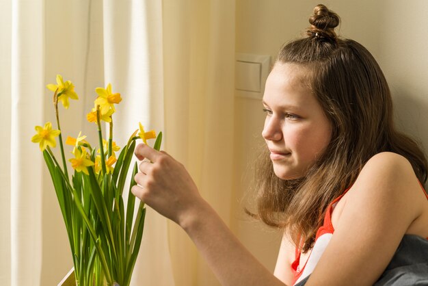 Tiener en boeket van gele lentebloemen