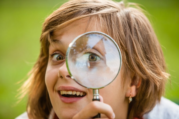 Tiener gebruikt vergrootglas om de natuur te ontdekken