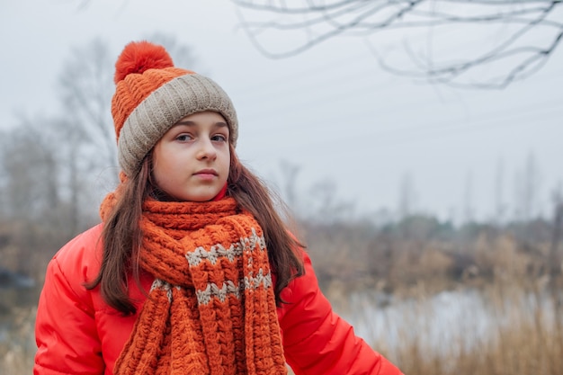 Tiener in oranje jasje.