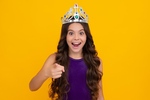 Tiener kind in koningin kroon geïsoleerd op gele achtergrond Prinses meisje in tiara Tienermeisje slijtage diadeem Opgewonden gezicht vrolijke emoties van tiener meisje