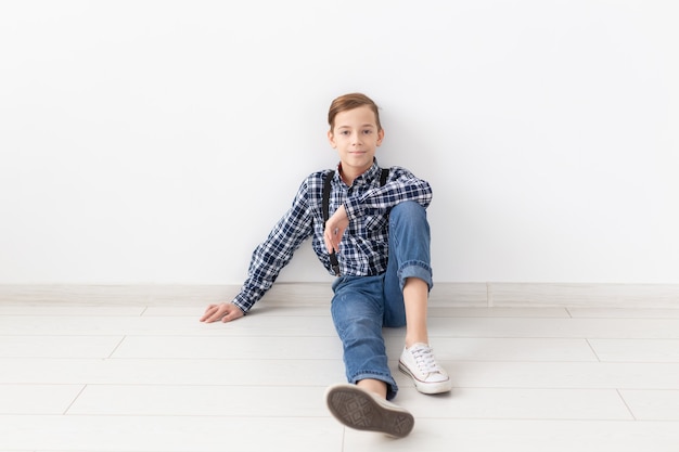 Tiener, kinderen en manierconcept - portret van een manier knappe jongen op de witte achtergrond met exemplaarruimte