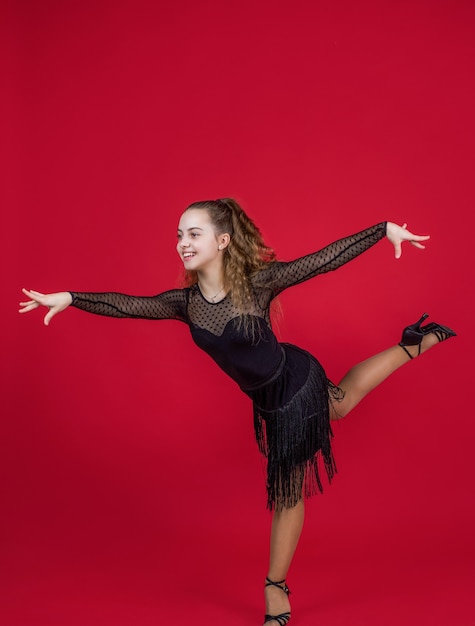 Tiener meisje mooie ballroomdanseres dragen zwarte jurk in dans pose, dansen.