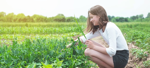 Tiener meisje raakt handen met groene planten in de tuin