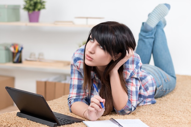 Tiener meisje studeren thuis liggend op de bank