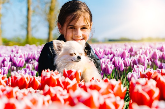 tiener meisje zittend op tulpenvelden in de regio Amsterdam, Nederland. Magisch landschap van Nederland met tulpenveld