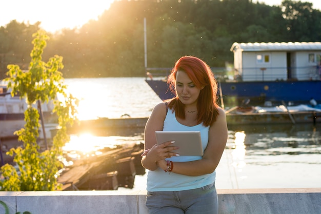 Tiener met rood haar die dichtbij de rivier ontspannen