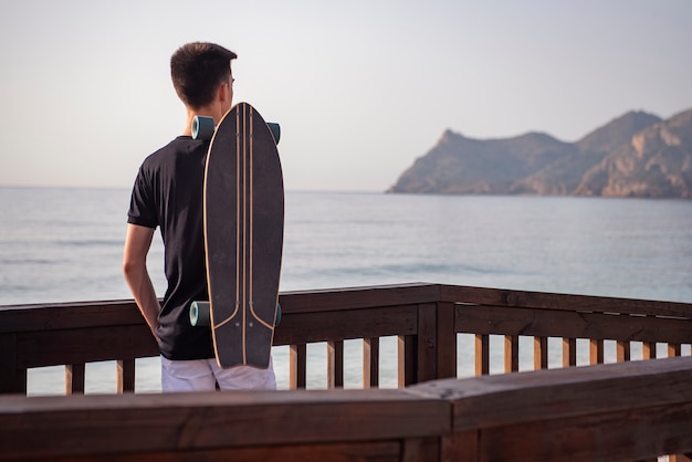 Tiener met zijn lange plank in promenade