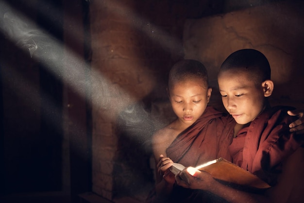 Tiener monniken die thuis een boek lezen.