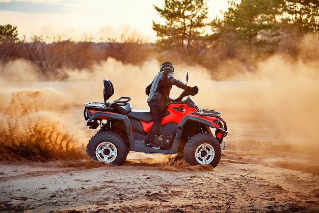 Tiener rijdt quad in zandduinen en maakt een bocht in het zand