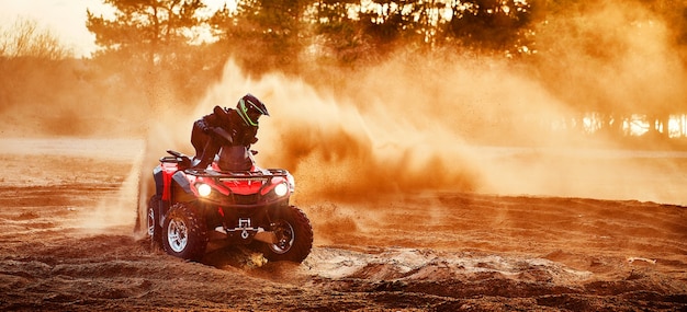 Tiener rijdt quad in zandduinen en maakt een bocht in het zand