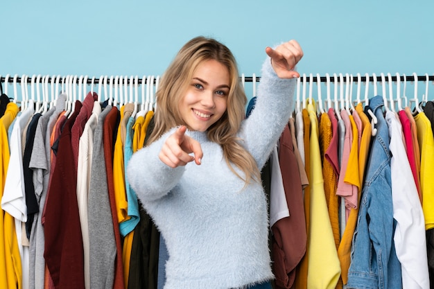 Tiener Russisch meisje die wat kleren op blauwe puntenvinger kopen bij u terwijl het glimlachen