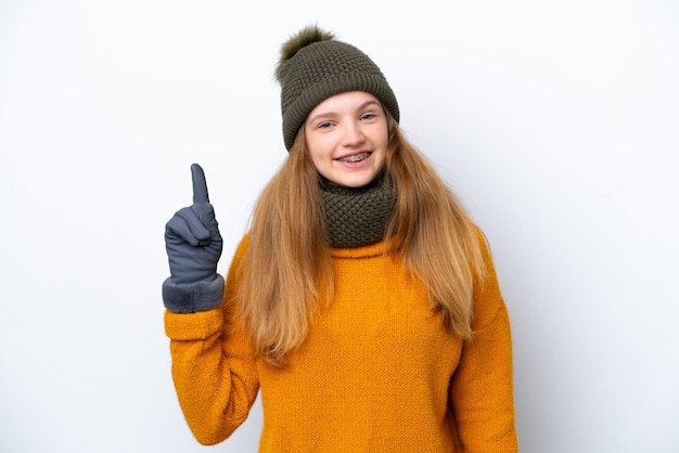 Tiener Russisch meisje met een winterjas geïsoleerd op een witte achtergrond die een vinger toont en optilt in teken van de beste