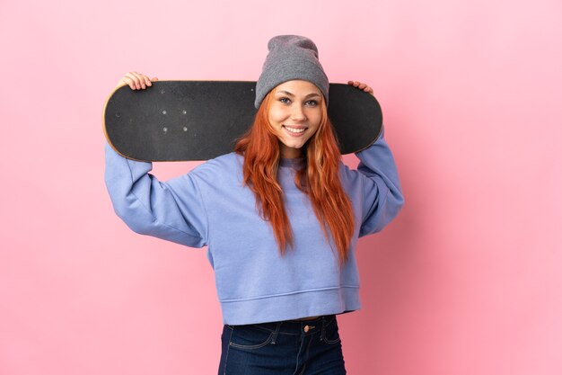 Tiener Russisch meisje op roze met een skate met gelukkige uitdrukking