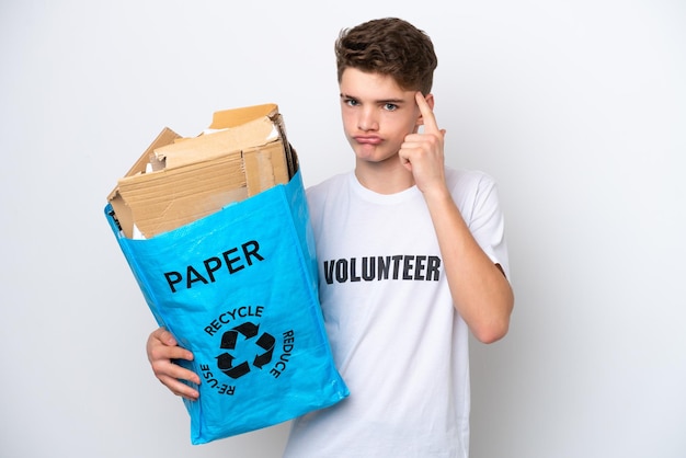 Tiener Russische man met een recyclingzak vol papier om te recyclen geïsoleerd op een witte achtergrond, denkend aan een idee