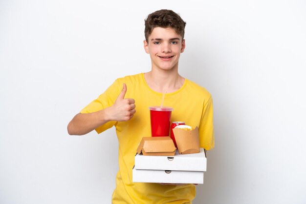 Tiener Russische man met fastfood geïsoleerd op een witte achtergrond met een duim omhoog gebaar
