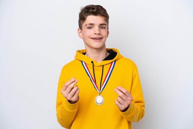 Tiener Russische man met medailles geïsoleerd op een witte achtergrond geld gebaar maken