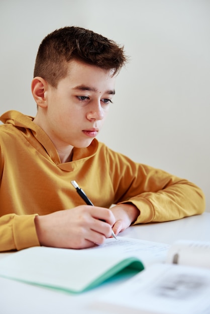 Tiener schrijft thuis huiswerk