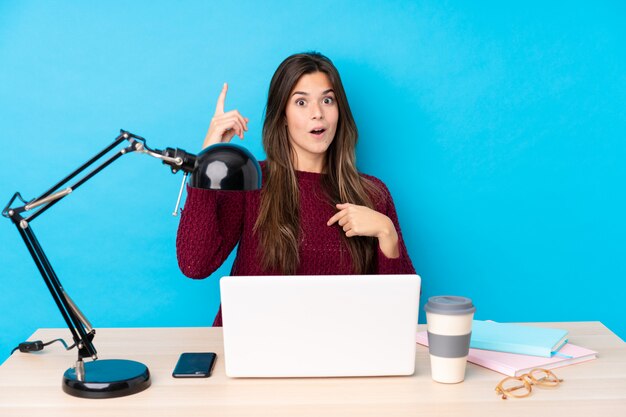 Tiener student meisje op een werkplek over blauwe muur