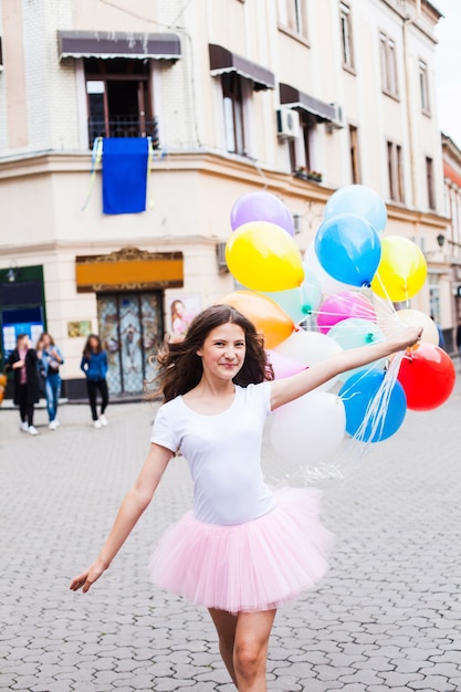 Tiener verjaardag. Mooi meisje met grote kleurrijke ballonnen in de straat van een oude stad