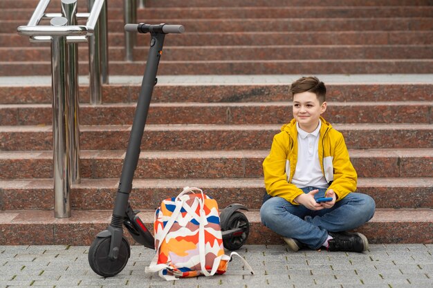 Foto tiener zit op de trap met mobiele telefoon