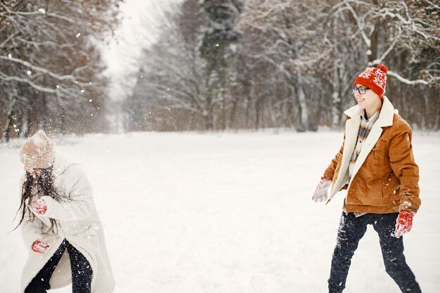 Tienerbroer en zus spelen sneeuwballen in het winterpark