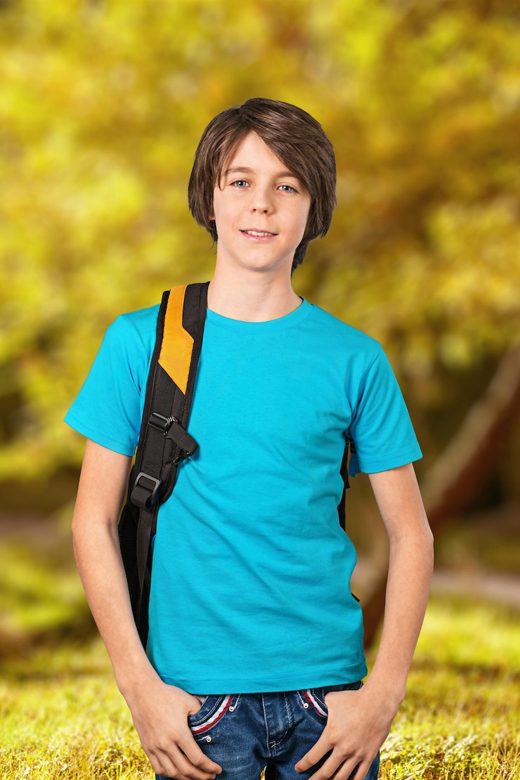 Foto tienerjongen met schooltas die bij camera glimlacht