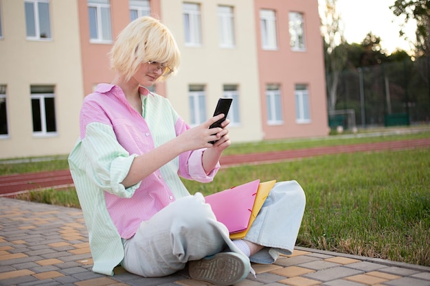 Tienermeisje buiten zitten en sms'en via de smartphone