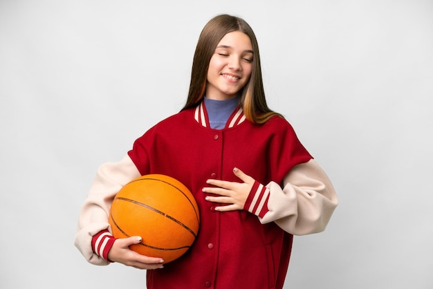 Tienermeisje dat basketbal speelt over een geïsoleerde witte achtergrond die veel glimlacht
