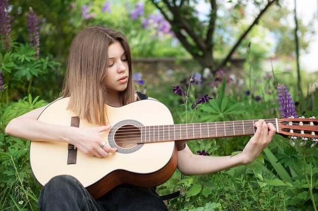 Tienermeisje dat gitaar speelt in het park