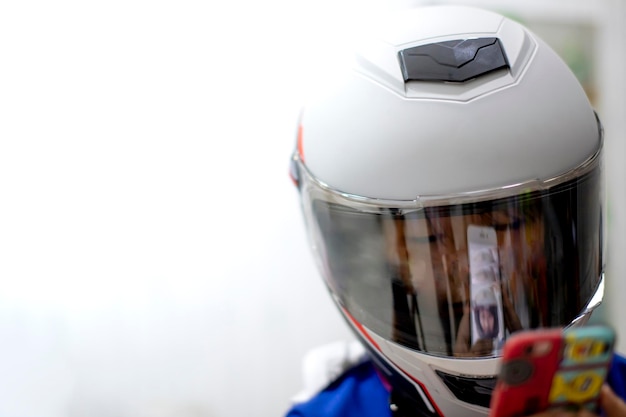 Tienermeisje draagt een helm terwijl ze buiten een smartphone gebruikt