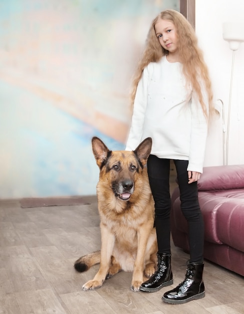 Tienermeisje en haar vriendelijke grote hond staan in de woonkamer