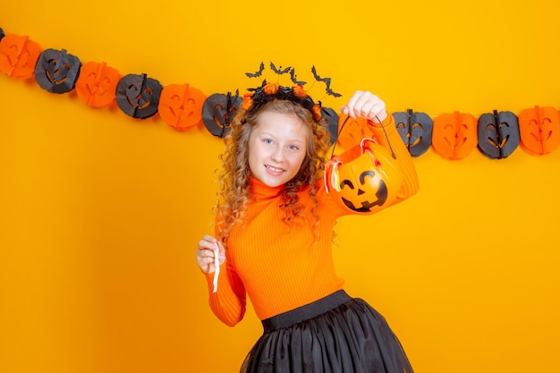 tienermeisje heks kostuum op gele achtergrond met confent pompoen marmelade wormen halloween