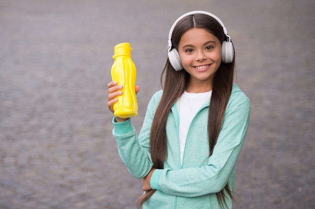 Tienermeisje houdt sportfles vast voor waterbalans in lichaams- en gezondheidshydratatie, gezonde jeugd.