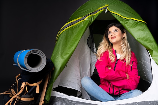 Tienermeisje in een camping groene tent