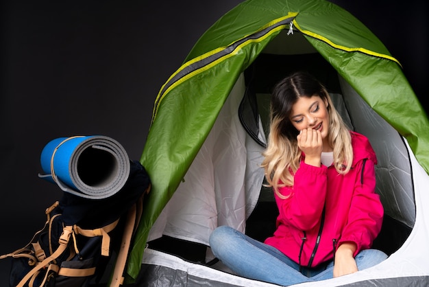 Tienermeisje in een camping groene tent