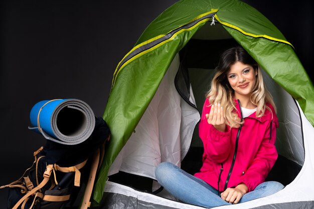 Tienermeisje in een camping groene tent