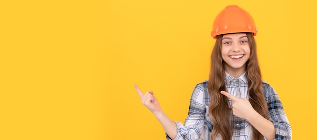 Tienermeisje in helm bouwer kind in geruit hemd bouw- en constructieconcept Kind in bouwvakker horizontaal posterontwerp Banner koptekst kopie ruimte